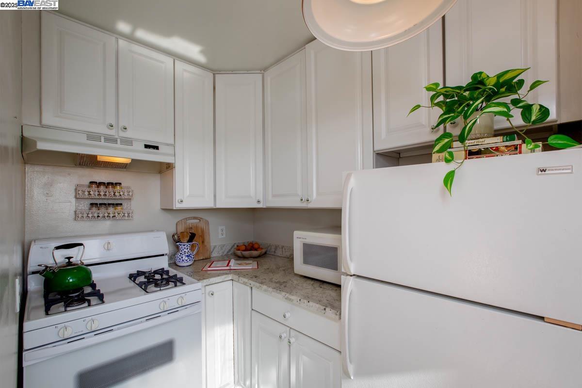 2000 Clinton Avenue Alameda, CA 94501 - Photo 17 of 57 a white kitchen with a refrigerator a stove and white cabinets
