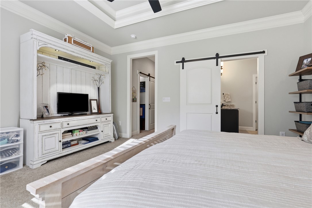 127 West Stewart Street Pelzer, SC 29669 - Photo 8 of 23 This spacious bedroom features a stylish barn door and elegant tray ceiling.