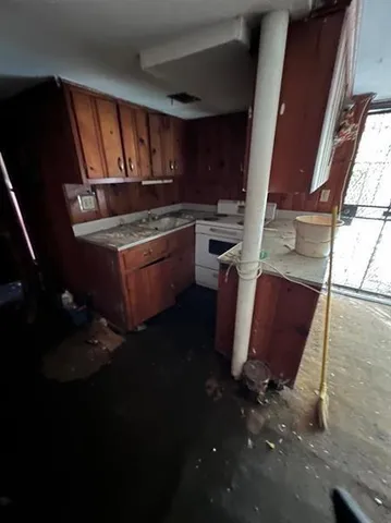 a kitchen with granite countertop sink stove and cabinets