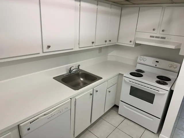 a kitchen with white cabinets and white appliances