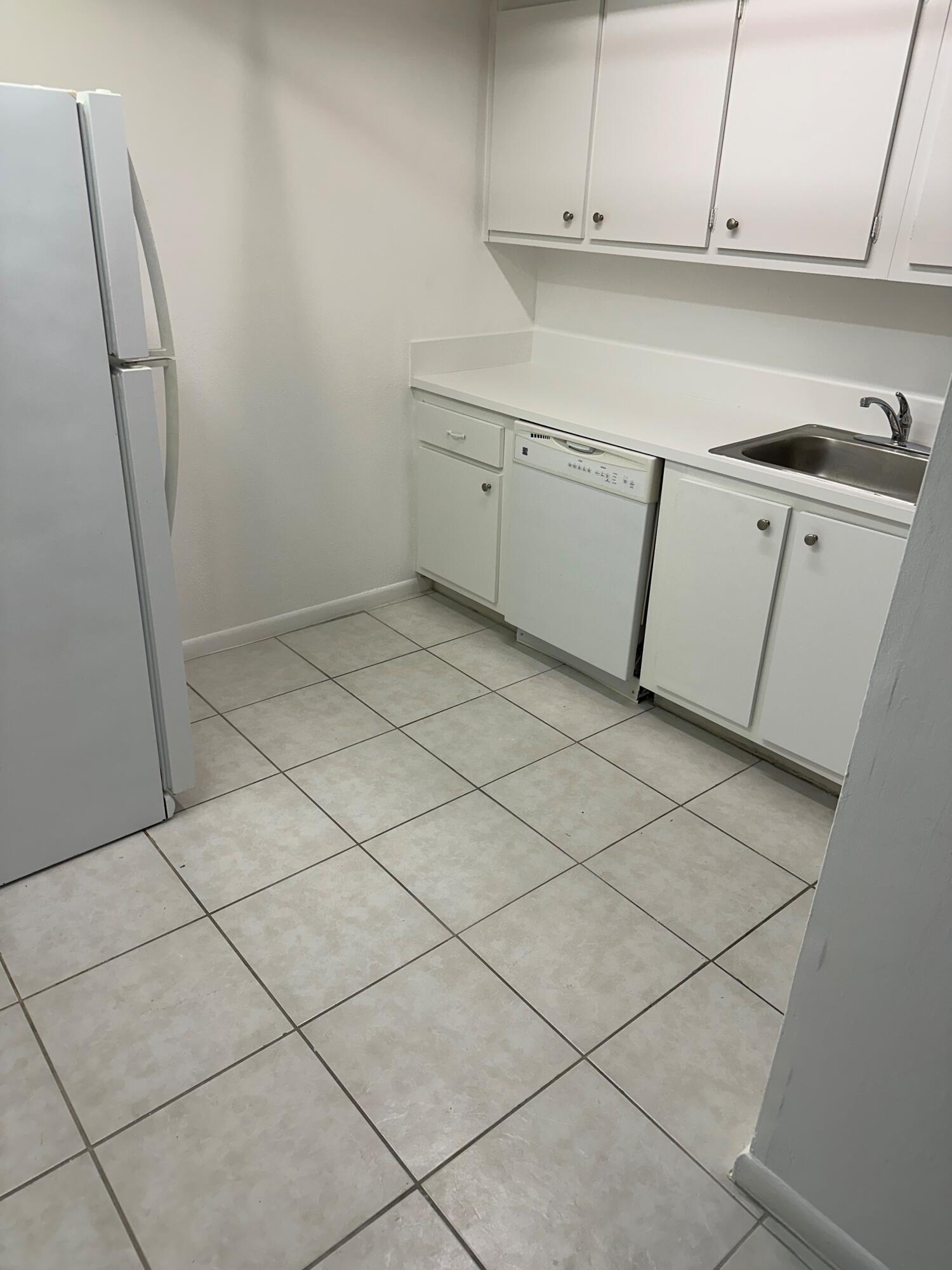 602 Northwest 13th Street, Unit 150 Boca Raton, FL 33486 - Photo 5 of 12 a kitchen with white cabinets and white appliances