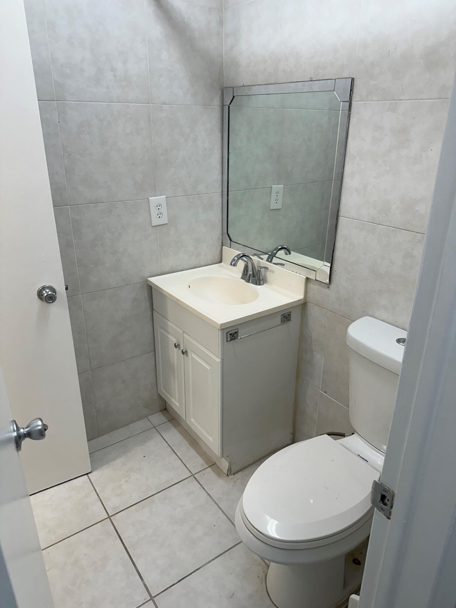 602 Northwest 13th Street, Unit 150 Boca Raton, FL 33486 - Photo 7 of 12 a bathroom with a sink a toilet and a mirror