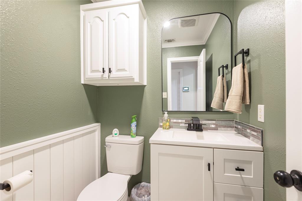 2020 Arbor Bend Road Bonham, TX 75418 - Photo 25 of 40 Downstairs half Bathroom off laundry room with a textured wall, vanity, ornamental molding, and wainscoting