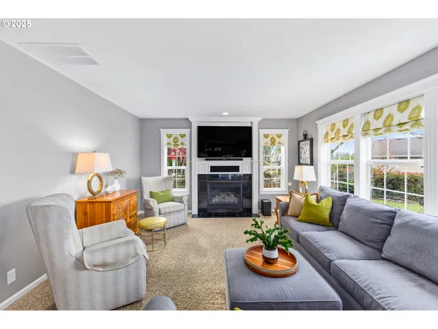 a living room with furniture flat screen tv and large window