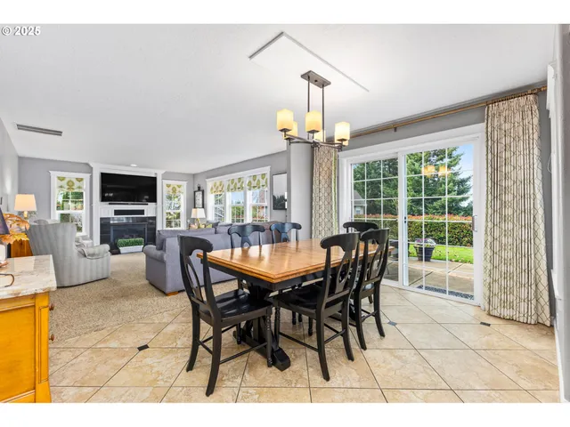 a dining room with furniture a chandelier and a flat screen tv