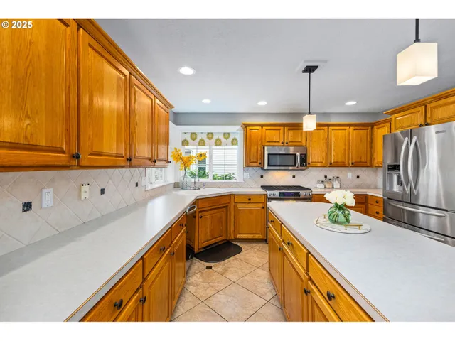 a kitchen with a sink a counter top space cabinets stainless steel appliances and a window