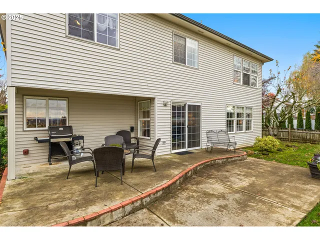 a backyard of a house with table and chairs