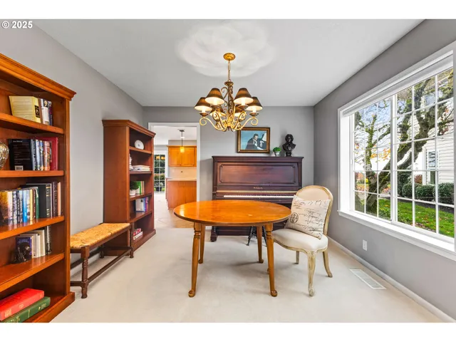 a living room with furniture a bookshelf and a window