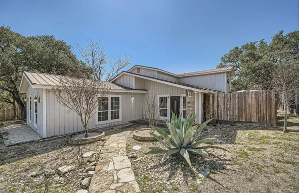a view of a house with backyard and trees