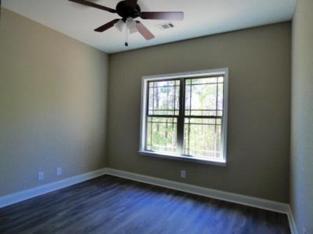 211 Timber Ridge Boulevard Byron, GA 31008 - Photo 13 of 31 a view of an empty room with wooden floor and a window