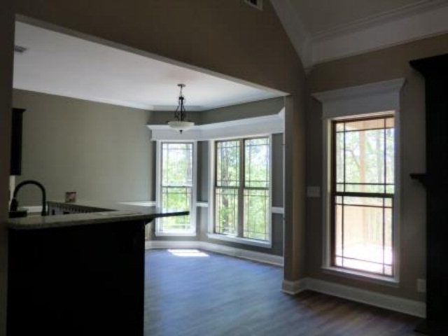 211 Timber Ridge Boulevard Byron, GA 31008 - Photo 9 of 31 a kitchen with kitchen island a sink wooden floor and a large window