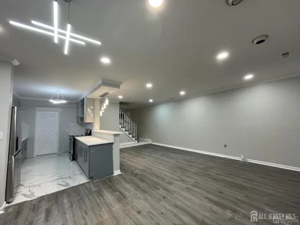 an empty room with wooden floor windows and fireplace