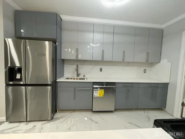a kitchen with stainless steel appliances granite countertop a refrigerator a sink and a stove