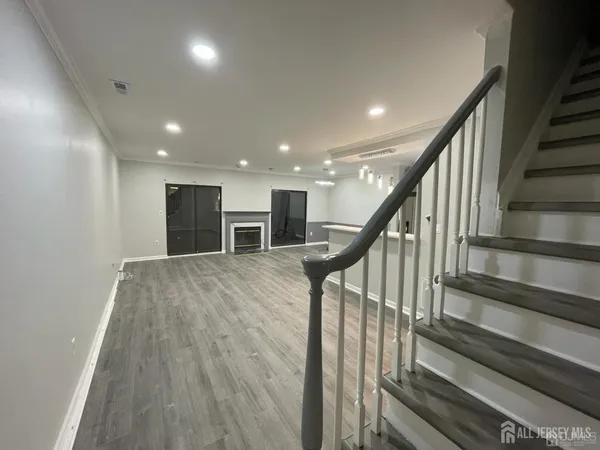 a view of a hallway with wooden floor and stairs