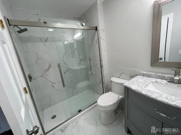 a bathroom with a granite countertop sink toilet and shower