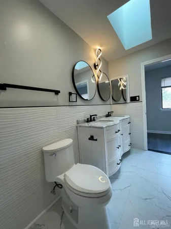 a bathroom with a toilet a sink and mirror