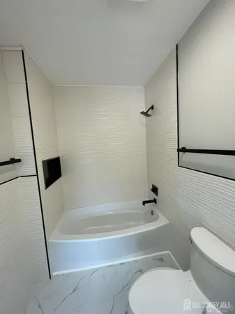 a bathroom with a toilet and a bath tub