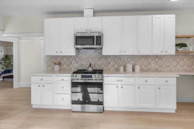 a kitchen with white cabinets and appliances