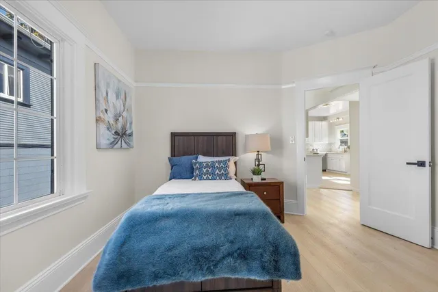 a bedroom with a large bed and wooden floor
