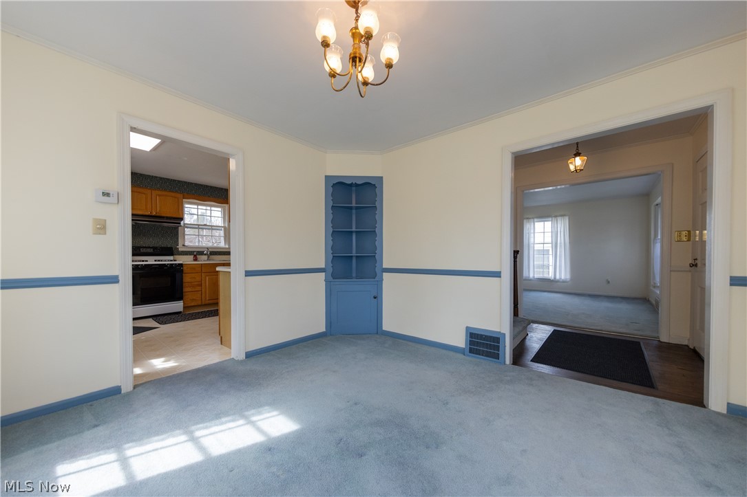1050 Renfield Road Cleveland Heights, OH 44121 - Photo 11 of 41 Dining room with a notable chandelier, ornamental molding, carpet floors, and a wealth of natural light