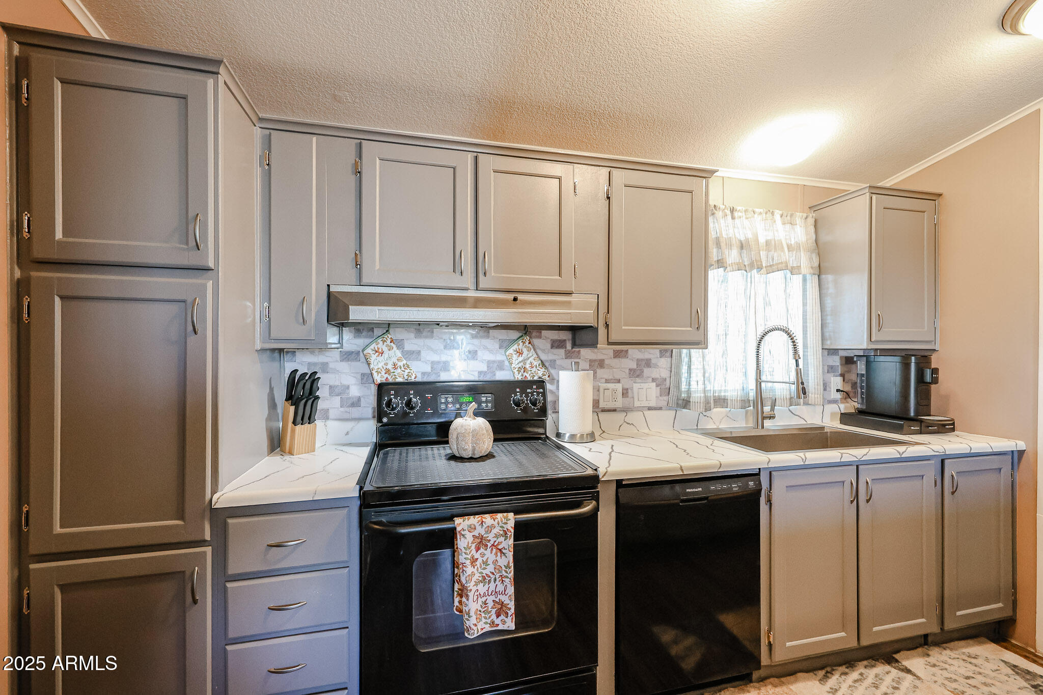 19602 North 32nd Street, Unit 32 Phoenix, AZ 85050 - Photo 21 of 37 a kitchen with granite countertop a refrigerator sink and cabinets