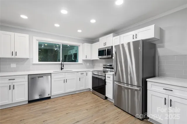 a kitchen with stainless steel appliances a refrigerator sink and microwave