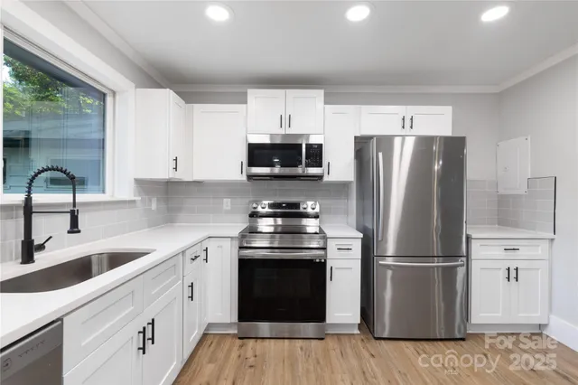 a kitchen with a refrigerator sink and wooden floor