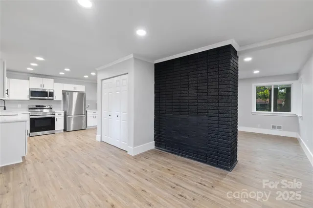 a view of kitchen with wooden floor and electronic appliances