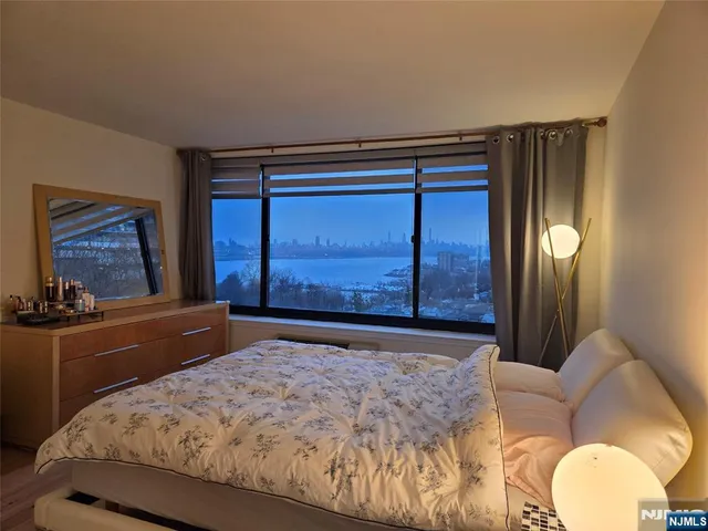 a bedroom with a bed and dresser with mirror