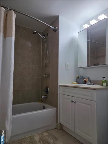 a bathroom with a tub a sink and mirror