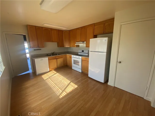 a kitchen with a refrigerator a stove and wooden cabinets