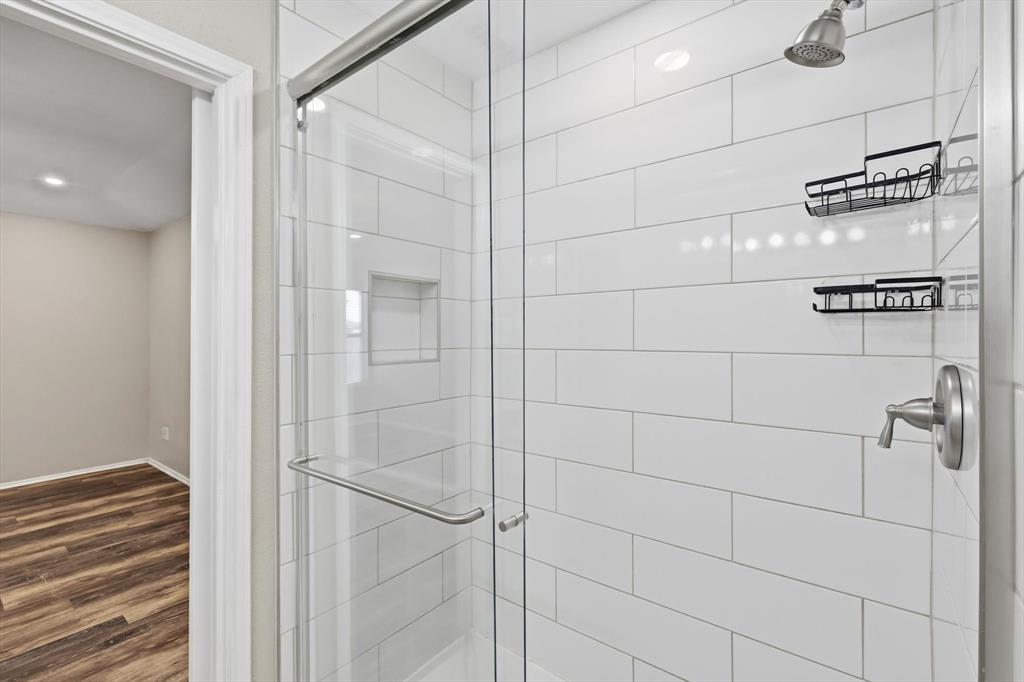 7733 Liz Lane Watauga, TX 76148 - Photo 19 of 27 Full bath featuring a shower stall, dark wood-style flooring, and recessed lighting