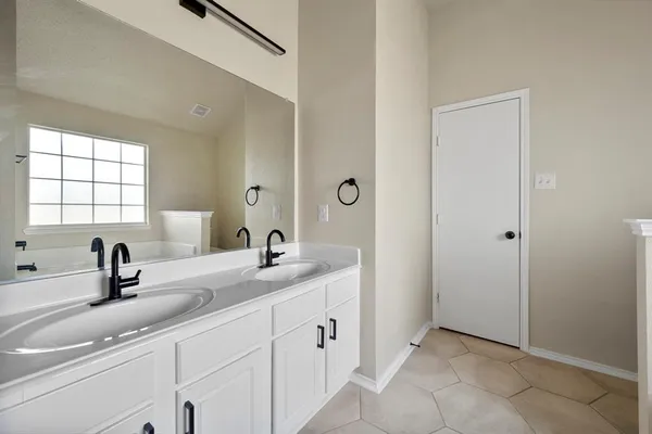 a bathroom with a double vanity sink and mirror