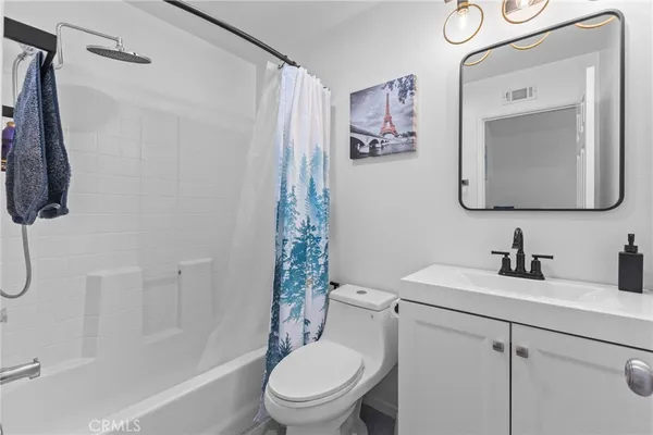 a bathroom with a toilet sink vanity tub and shower