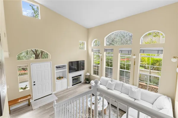 a living room with furniture a flat screen tv and a window