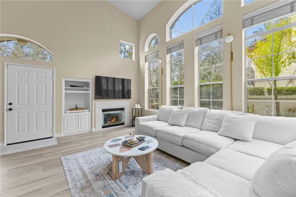a living room with furniture a fireplace and a large window