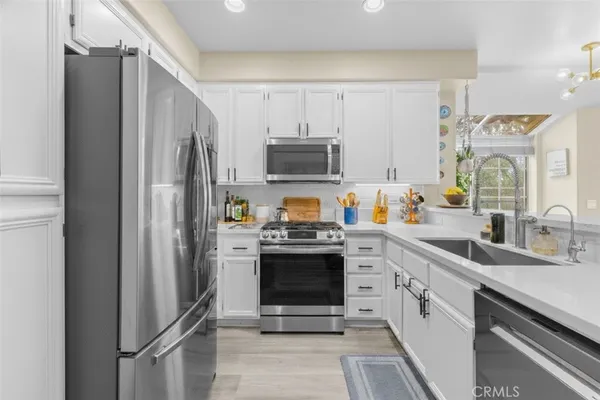 a kitchen with stainless steel appliances granite countertop a refrigerator stove and sink