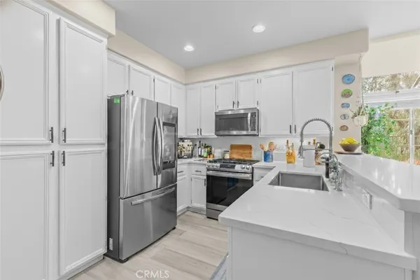 a kitchen with a refrigerator a stove a sink a microwave and cabinets