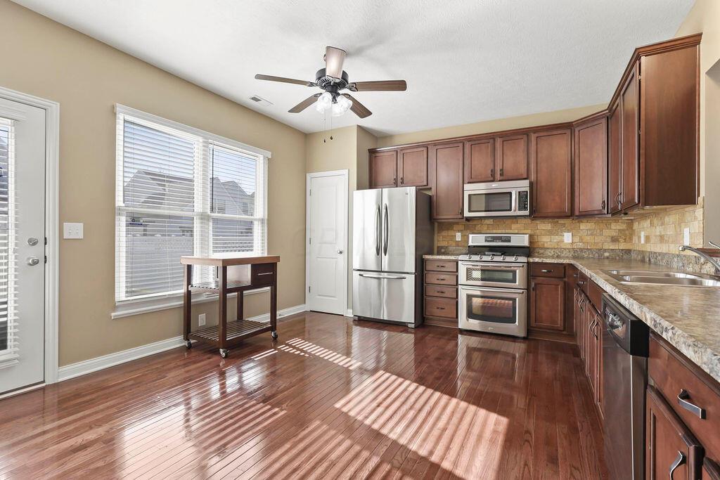 6163 Jennis Road Westerville, OH 43081 - Photo 10 of 44 • Hardwood flooring
• Tan painted walls
• 42” cabinets
• Tumbled marble backsplash
• Beveled edge countertops
• Maytag® dishwasher
• Double bowl, stainless
steel sink with sprayer
• New Badger® disposal
~ 2022
• Pass through to Great Room
• Whirlpool® microwave
• Maytag® gas range with
double oven
• Maytag® refrigerator
• Pantry closet
• Ceiling light
• 2” blinds
• Atrium door to paver patio