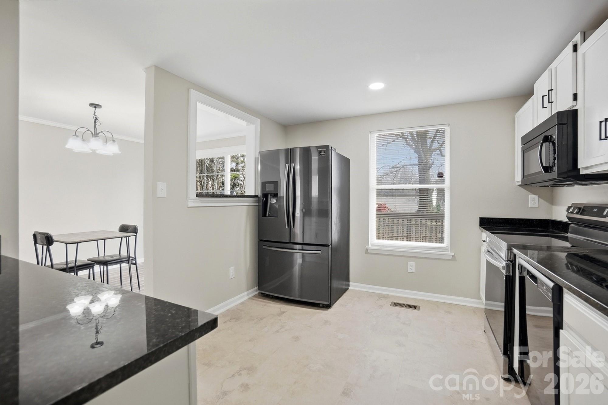 6621 Piney Path Road Charlotte, NC 28212 - Photo 4 of 36 a kitchen with stainless steel appliances granite countertop a refrigerator a stove a sink a microwave and island