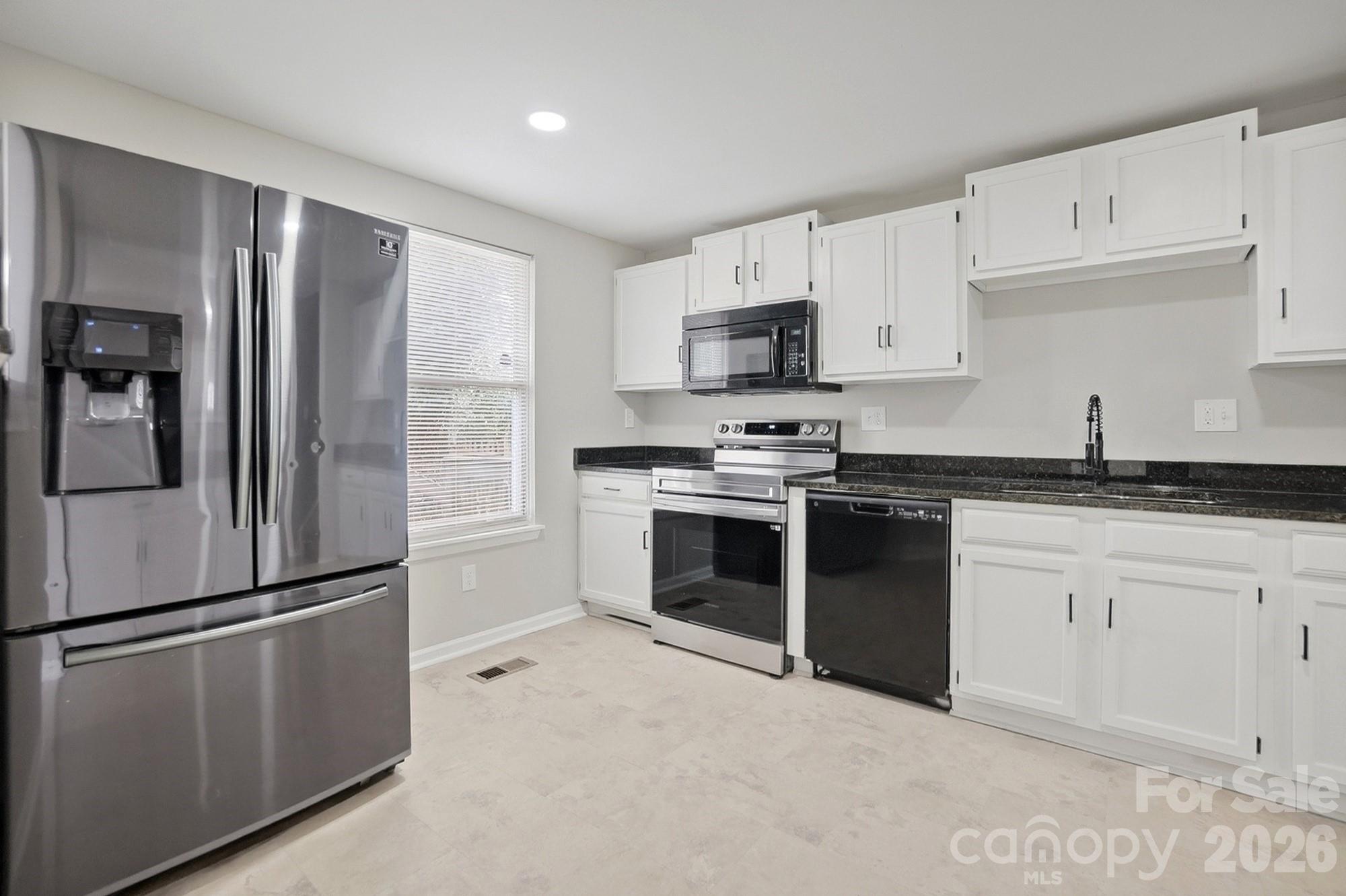 6621 Piney Path Road Charlotte, NC 28212 - Photo 5 of 36 a kitchen with stainless steel appliances and white cabinets