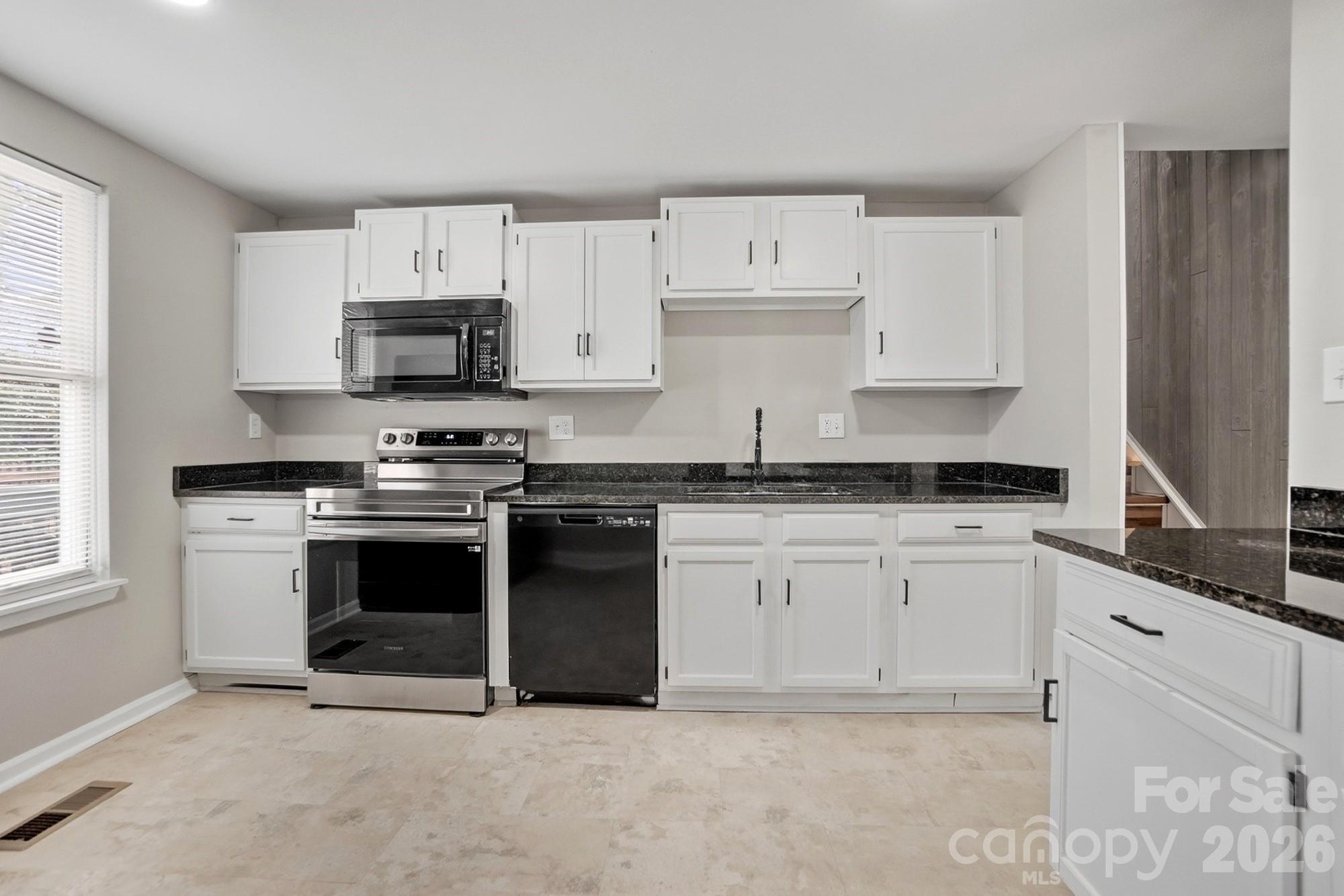 6621 Piney Path Road Charlotte, NC 28212 - Photo 6 of 36 a kitchen with granite countertop white cabinets and stainless steel appliances