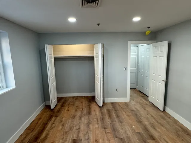 an empty room with wooden floor and entrance
