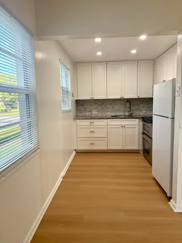 a kitchen with a refrigerator and a stove top oven