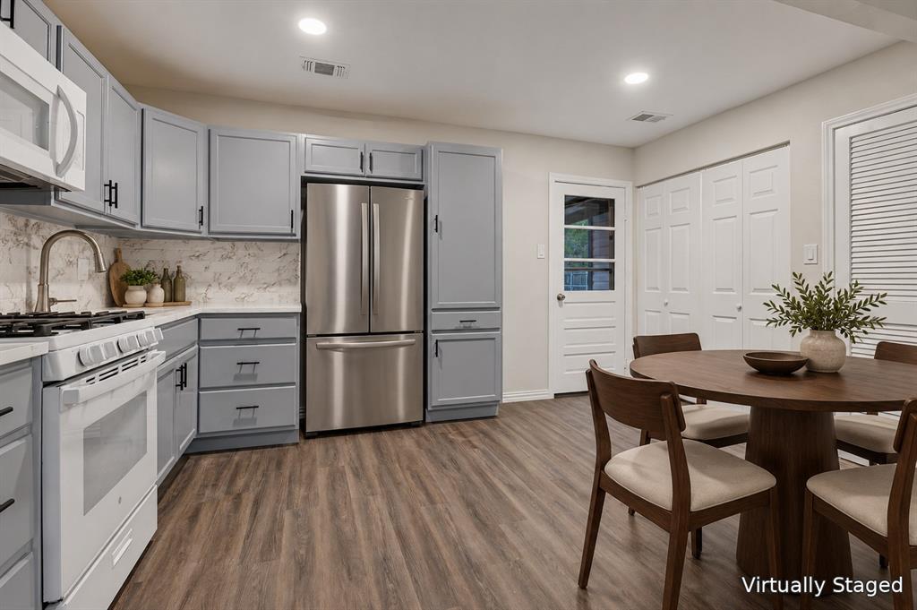 514 Chickapoo Trace Grand Prairie, TX 75051 - Photo 12 of 25 Kitchen featuring gray cabinetry, stainless steel refrigerator, white range, wood-finish flooring, and a white paneled door with glass inserts