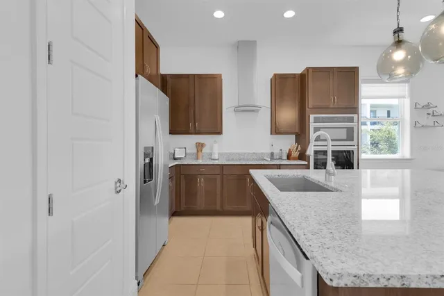 a kitchen with a sink a refrigerator and cabinets