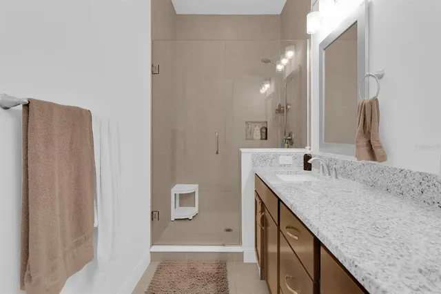 a kitchen with stainless steel appliances granite countertop a stove top oven a refrigerator a sink and chairs