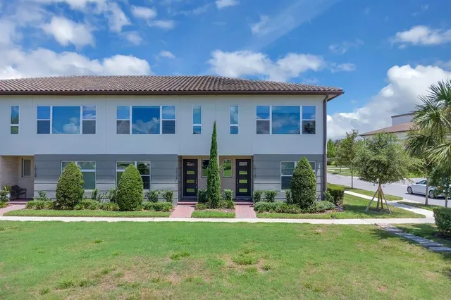 a view of a house with a big yard and large trees