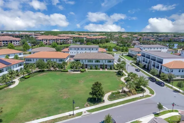 a view of a city with lawn chairs and large trees