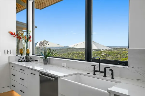 a bathroom with a granite countertop sink and a large mirror next to a window